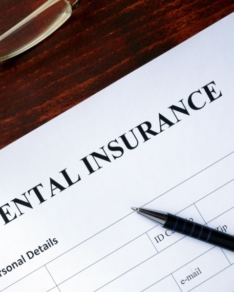 Pen and dental insurance paperwork on desk