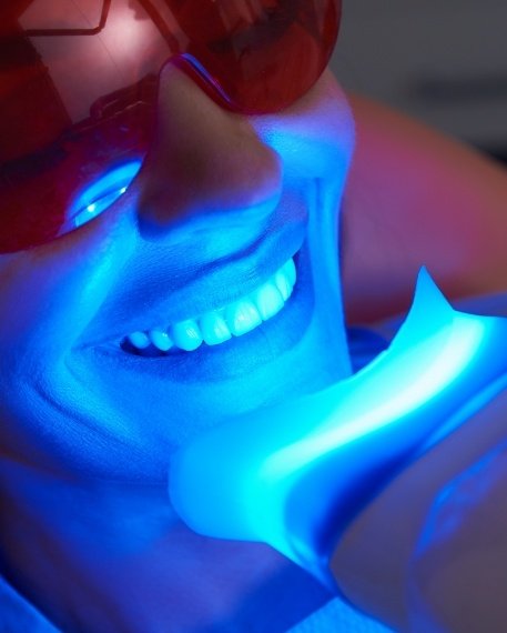 Woman receiving professional teeth whitening in dental office