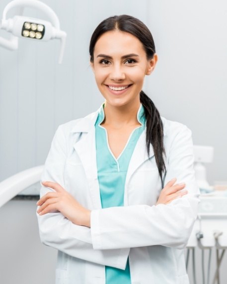 Smiling dentist standing with her arms crossed