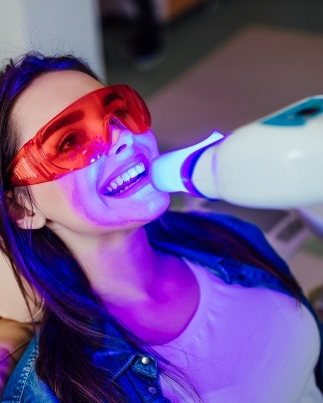 Woman getting professional teeth whitening in dental office