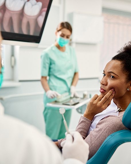Patient with toothache looking at dentist in treatment chair