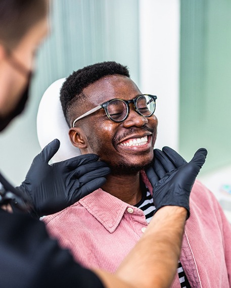 Dentist looking at smiling's patients teeth