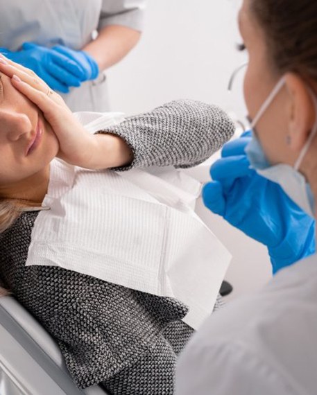 Lady with oral pain looks to dentist