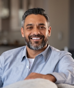 Man smiling while sitting in couch at home