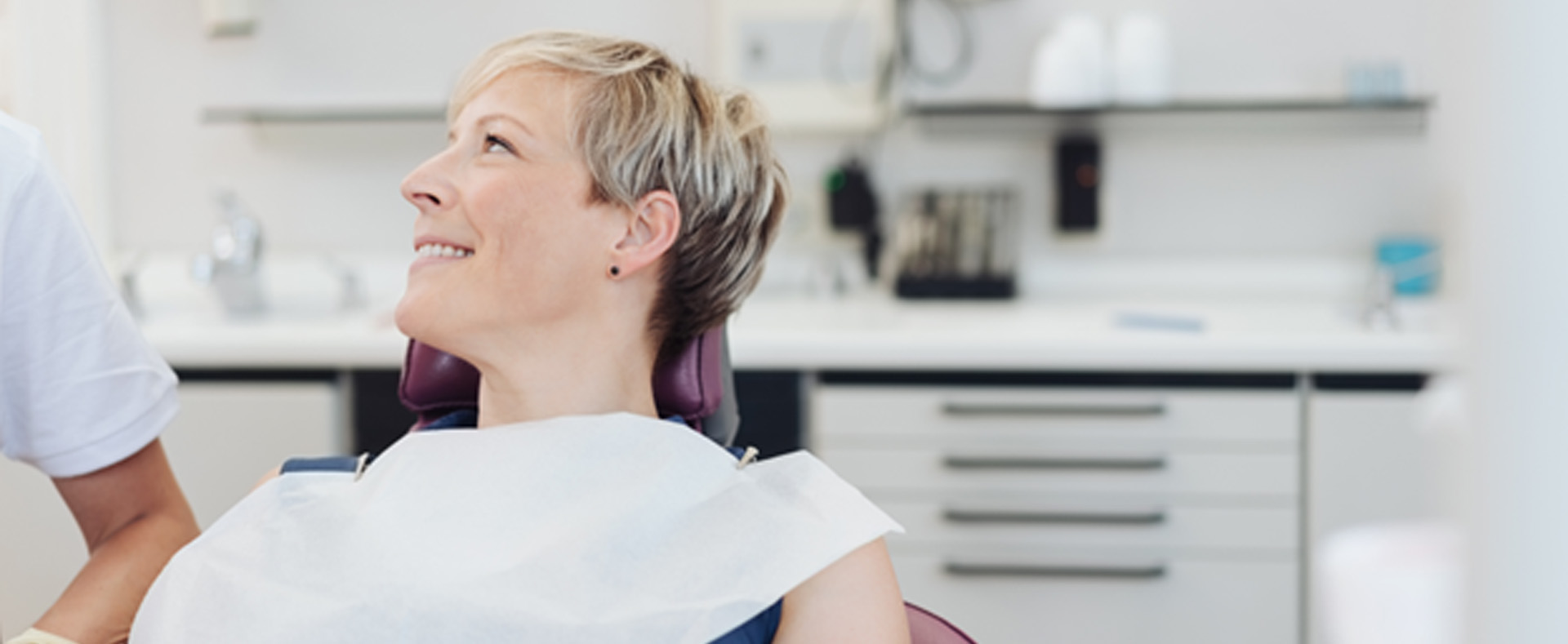 Middle-aged dental patient looking at her dentist