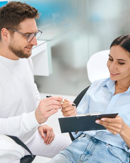 Dental patient filling out paperwork on clipboard