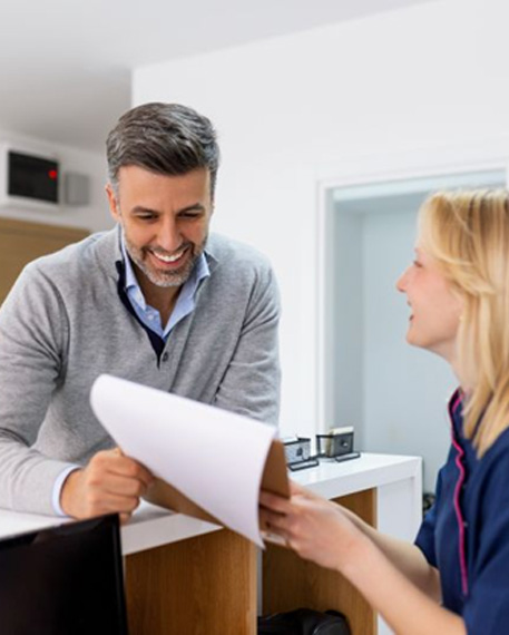 Dental team member helping patient at front desk