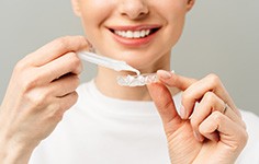 Woman applying whitening gel to tray
