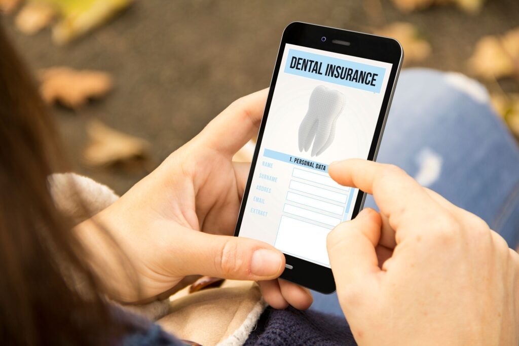 Woman looking at dental insurance form on smartphone