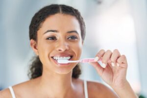 Woman brushing teeth.