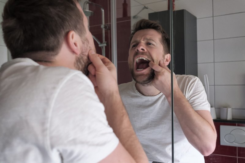 Patient checking dental crown in mirror