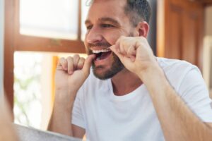 Man flossing his teeth.